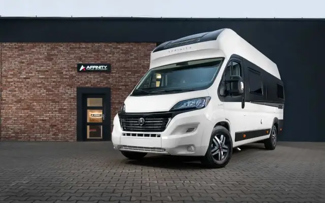 Nowy kamper van Affinity gotowy na przygodę. Biały, nowoczesny, z czarnymi akcentami. Idealny na wakacje.