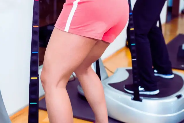 Ćwiczenia na platformie wibracyjnej przynoszą widoczne platforma wibracyjna efekty przed i po. Dwie osoby trenują, skupiając się na nogach.