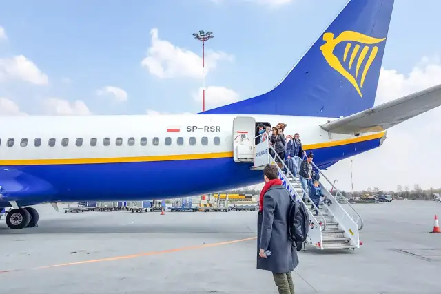 Pasażerowie wsiadają po schodkach do samolotu Ryanair.