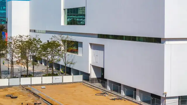 Nowoczesny budynek muzeum sztuki współczesnej w Warszawie, z białymi, geometrycznymi fasadami i dużymi oknami.