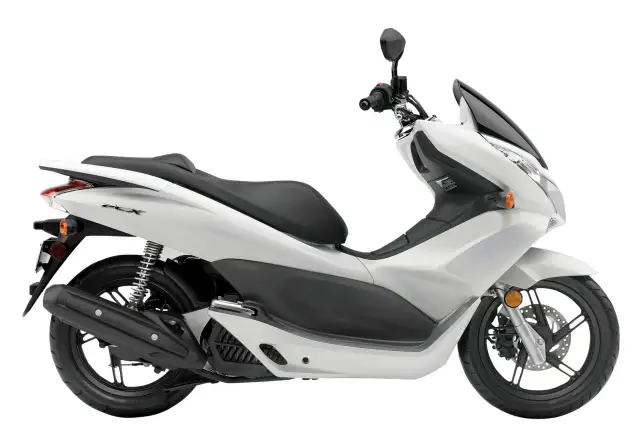Biały skuter Honda PCX 125, znany z niskiego spalania, na białym tle.