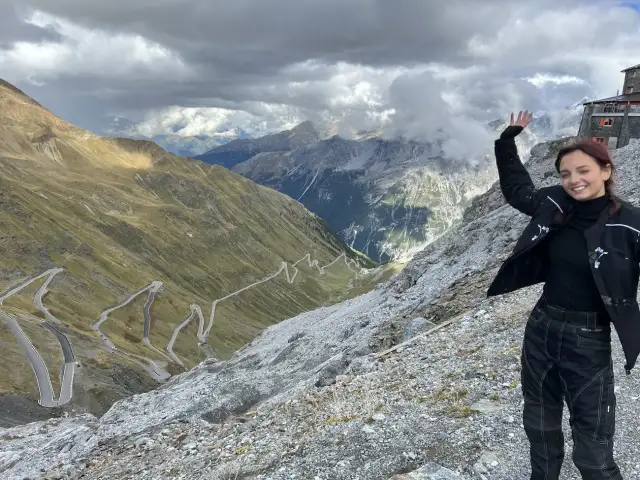 Uśmiechnięta motocyklistka na tle serpentyn w Alpach. Niesamowita przygoda na alpy motocyklem!