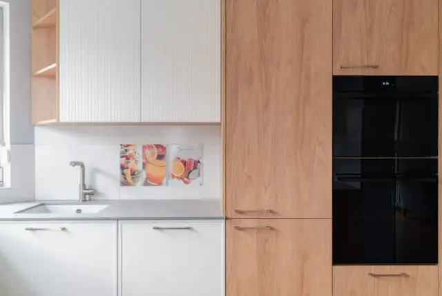 Nowoczesna kuchnia z białymi frontami i drewnianymi elementami. Decyzja: fronty lakierowane czy akrylowe? Wybór należy do Ciebie!