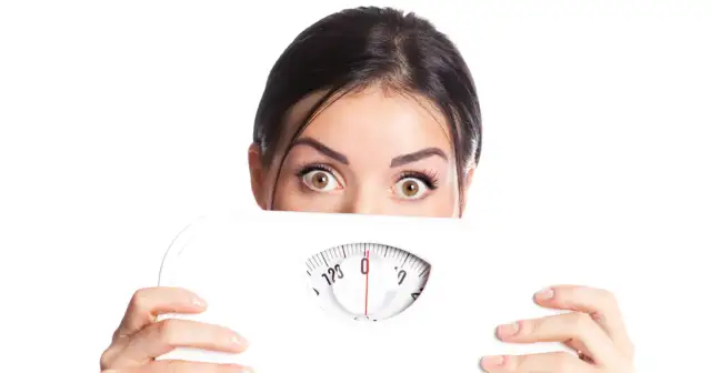 Zaskoczona kobieta z wagą łazienkową. Czy to sekret, co odchudza najszybciej?