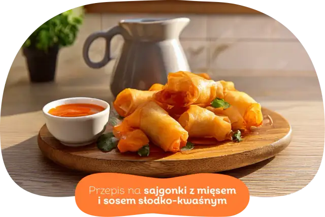 Chrupiące wege sajgonki z warzywami i sosem słodko-kwaśnym na drewnianej desce. Idealne na przekąskę.