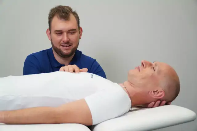 Fizjoterapeuta uspokaja pacjenta, który odczuwa nerwowość i agresję.