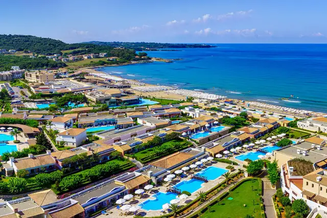 Idealne wakacje na Peloponezie: rozległy kompleks hotelowy z basenami i plażą nad turkusowym morzem.