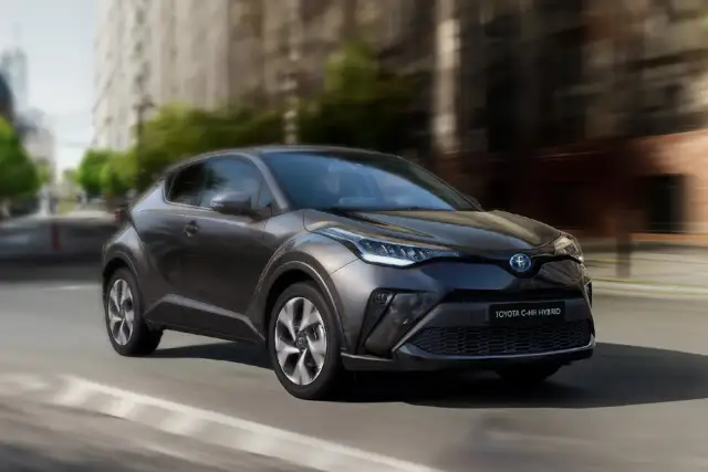 Ciemnoszara Toyota C-HR Hybrid w ruchu miejskim. Zastanawiasz się, ile pali Toyota C-HR Hybrid? Ten stylowy crossover zachwyca niskim spalaniem.