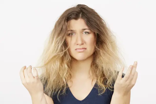 Kobieta z rozczochranymi włosami, wyrażająca niezadowolenie. Wygląda na to, że ma dziś **bad hair day**.