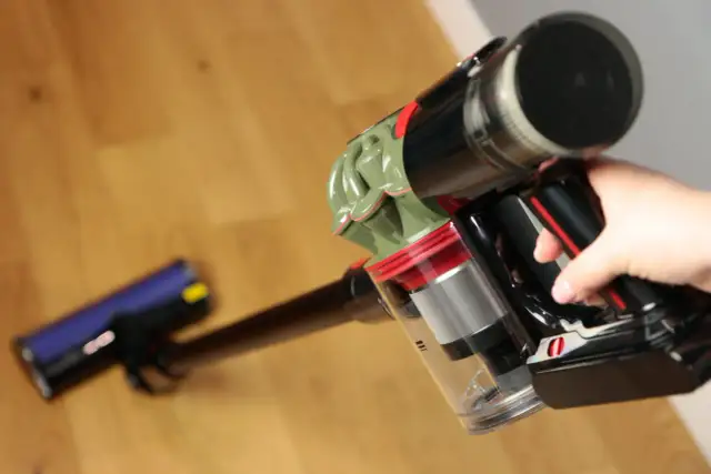 Ręka trzyma odkurzacz Dyson V8. Czy warto? Zobacz, jak łatwo sprząta podłogę.