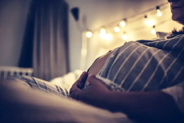 Czekając na poród, czuję skurcze co godzinę. Brzuch rośnie, a światła tworzą ciepłą atmosferę.