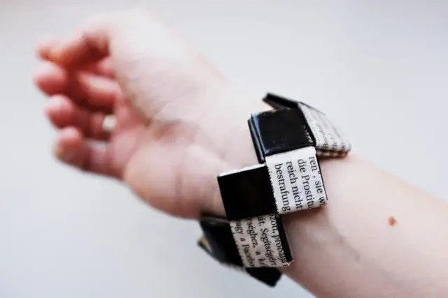 Bransoletka z papieru z tekstem na ręce.