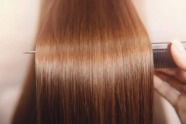 Gładkie, brązowe włosy czesane grzebieniem. Zastanawiasz się, ile utrzymuje się botox na włosach? Efekt utrzymuje się kilka miesięcy.