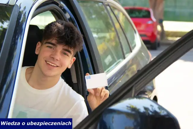 Uśmiechnięty młody kierowca oc pokazuje kartę ubezpieczenia.