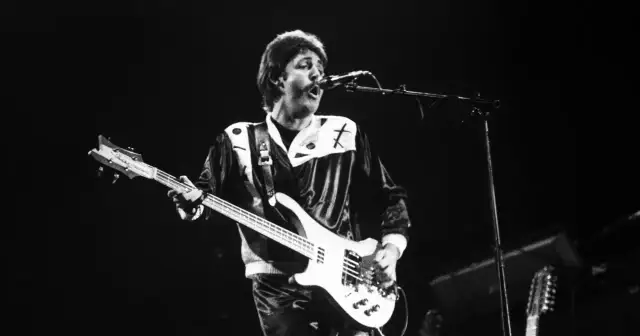 Paul McCartney, jeden z legendarnych amerykańscy piosenkarze lat 80., gra na gitarze basowej podczas koncertu.