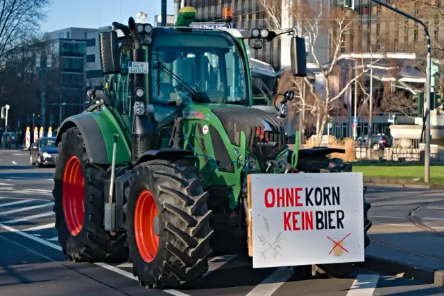 Zielony ład o co chodzi? Traktor z tablicą "Ohne Korn kein Bier" na ulicy.