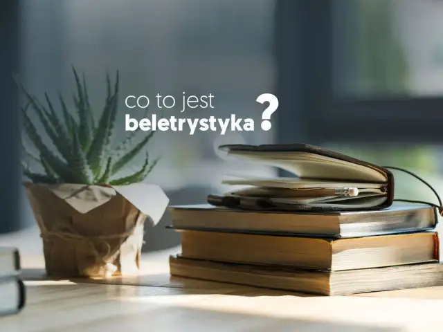Co to jest beletrystyka? Stos książek i notes z ołówkiem na biurku, obok rośliny.