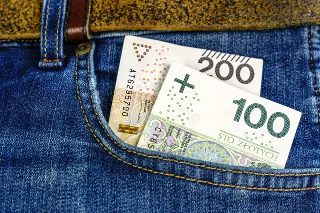 Polskie banknoty 100 i 200 zł w kieszeni dżinsów.