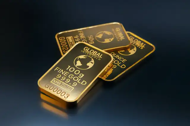 Trzy sztabki złota z napisem "Global Intergold" i globusem.