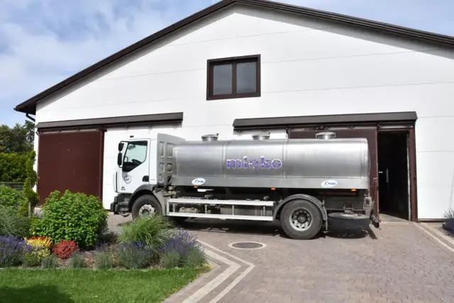 Ciężarówka z cysterną na mleko przed budynkiem. Sprawdź aktualne ceny mleka przerzutowego.