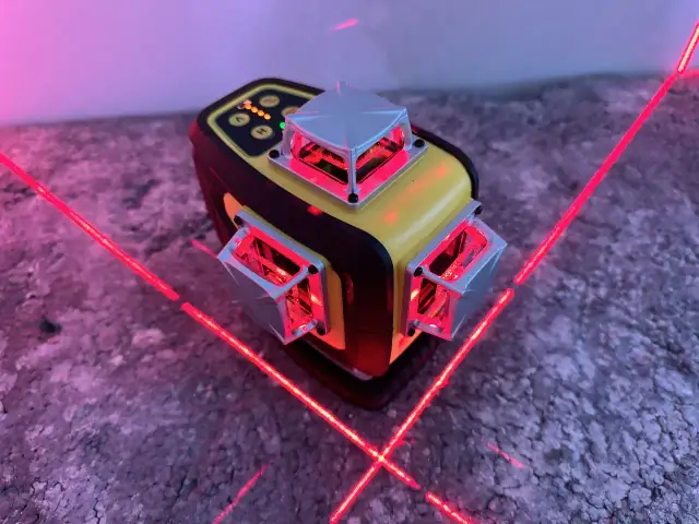 Poziomica laserowa z czerwonymi liniami laserowymi emitowanymi z kilku modułów.