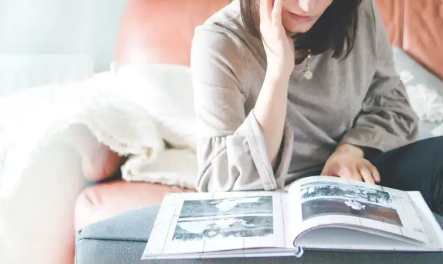 Kobieta przegląda album ze zdjęciami. Format 13x18 jaki to format? To klasyczny rozmiar, idealny do wspomnień.