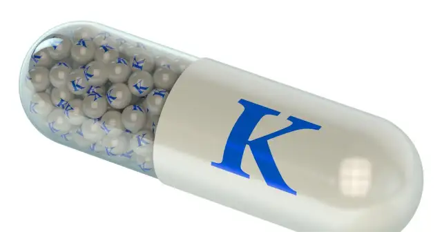 Kapsułka z małymi kulkami z literą "K" i dużą literą "K" na obudowie.