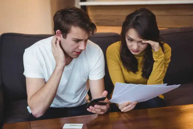 Para zmartwiona przegląda dokumenty, zastanawiając się, czy długi się przedawniają.
