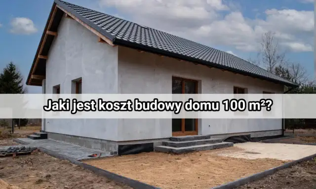 Niedokończony dom z szarym tynkiem i czarnym dachem, otoczony placem budowy.