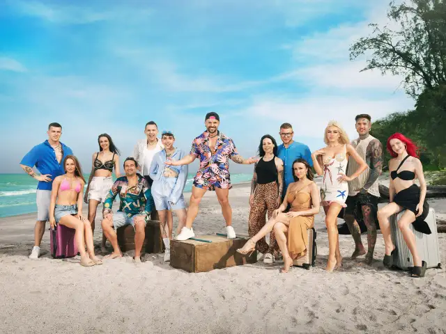 Grupa młodych ludzi na plaży, gotowa na przygodę. Trzymają walizki, a ich stroje sugerują wakacyjny klimat. good luck guys!