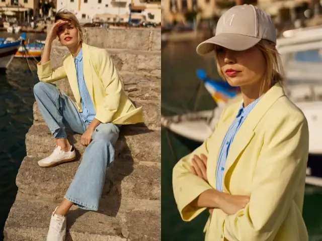 Kobieta w żółtej marynarce i jeansach, tworząca modne stylizacje nad wodą. W drugiej części zdjęcia w bejsbolówce.