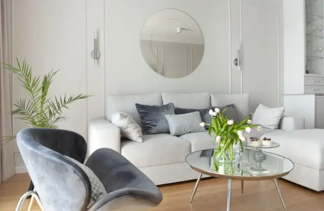 Szare akcenty i zieleń rośliny idealnie komponują się z białymi ścianami, tworząc przytulne wnętrze.