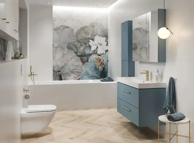 Nowoczesna łazienka z tapetą w kwiaty, błękitną zabudową i złotymi detalami. Zastanawiasz się, ile trwa remont małej łazienki?