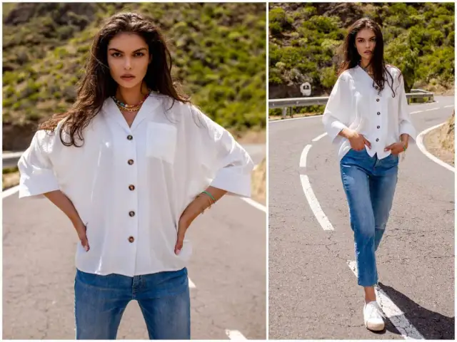 Kobieta w białej koszuli i jeansach na drodze.