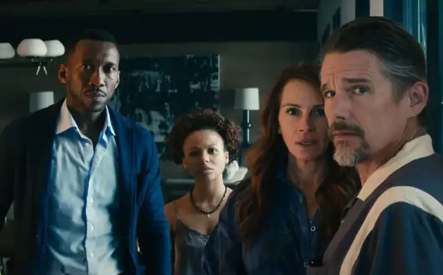 Cztery osoby stoją w pomieszczeniu, ich twarze wyrażają niepokój. Czyżby chcieli zostawić świat za sobą?