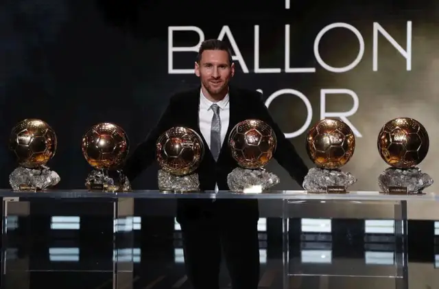 Lionel Messi stoi z siedmioma Złotymi Piłkami na tle napisu "BALLON D'OR".