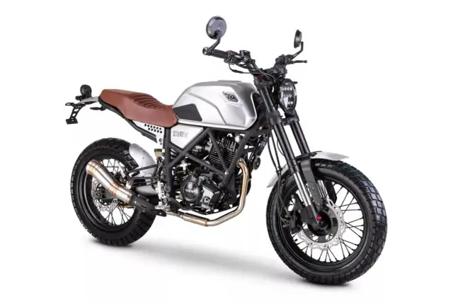 Srebrny Romet Scrambler 125 z brązowym siedzeniem i oponami terenowymi, gotowy na przygodę.