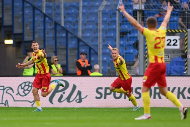 Piłkarze w żółto-czerwonych strojach świętują na boisku.