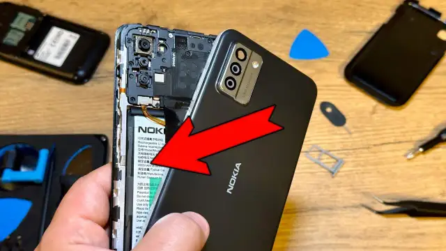 Wymiana baterii w telefonie Nokia. Czy przy wymianie baterii resetuje telefon? Narzędzia do naprawy leżą obok.