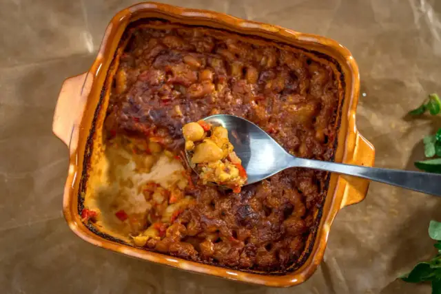 Pyszne tavce gravce, zapiekanka z ciecierzycy i fasoli, na łyżce.