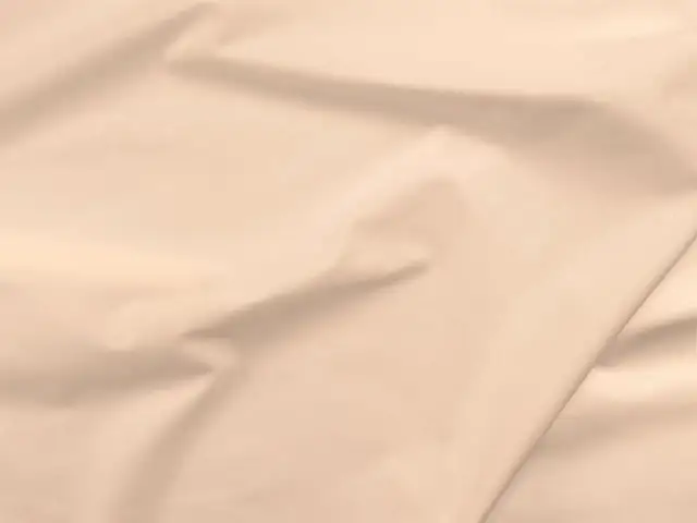 Gładka, beżowa popelina, która jest dobrym materiałem na letnie sukienki i koszule.