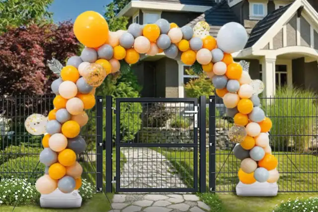 Stojak na balony instrukcja montażu: łuk balonowy w kolorach pomarańczowym, szarym i białym nad bramą.