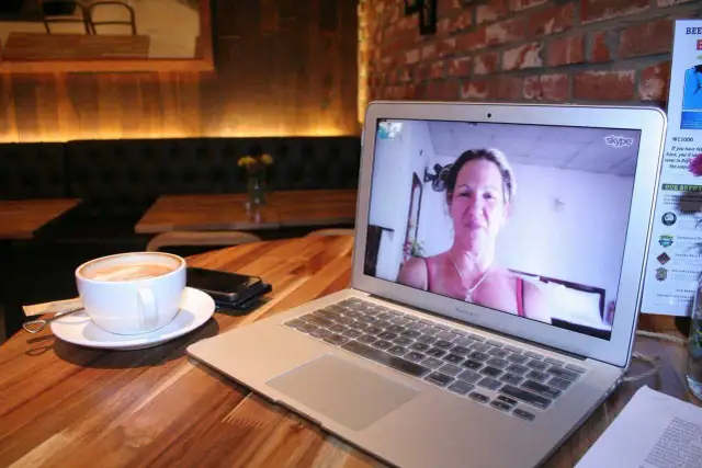 Kawa i laptop z rozmową przez Skype. Dowiedz się, jak zainstalować Skype na komputerze, by połączyć się z bliskimi.