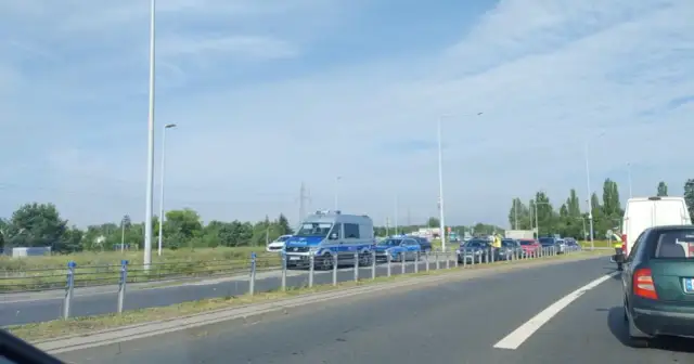 Korki w Toruniu. Policja kieruje ruchem na zakorkowanej drodze.