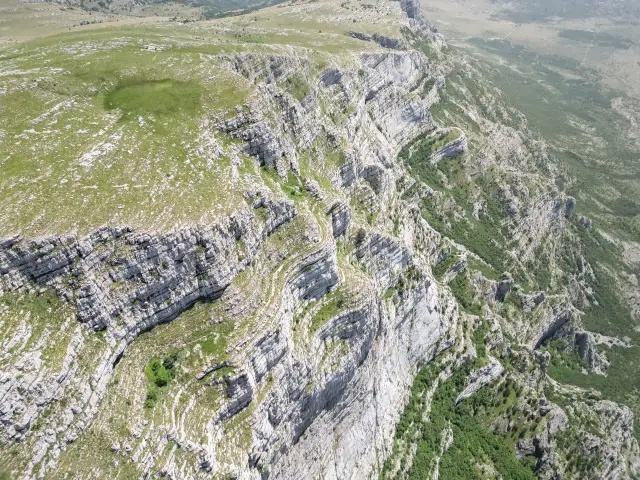 Imponujące klify i zielone zbocza gór Dinara w Chorwacji. Widok z lotu ptaka na surowy, skalisty krajobraz.