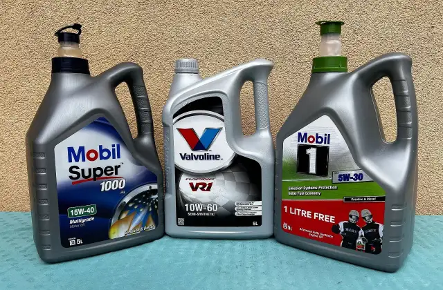 Trzy butelki oleju silnikowego: Mobil Super 1000, Valvoline VR1 i Mobil 1.