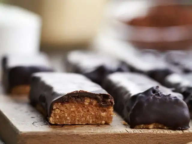 Domowe batony proteinowe oblane czekoladą. Idealne, gdy zastanawiasz się, jak zrobić batona proteinowego.