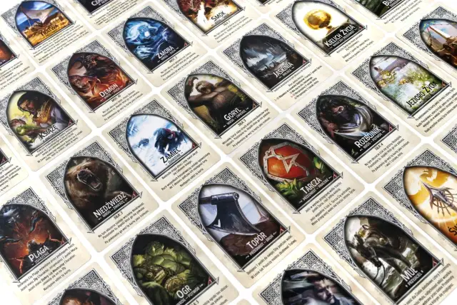 Widok z góry na wiele kart z ilustracjami postaci i przedmiotów fantasy, ułożonych w rzędach.