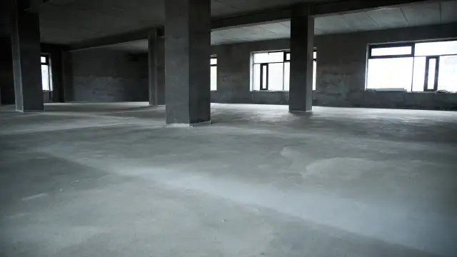 Surowa posadzka betonowa w pustym domu, idealna baza pod wykończenie. Jaki beton na posadzkę w domu wybrać?