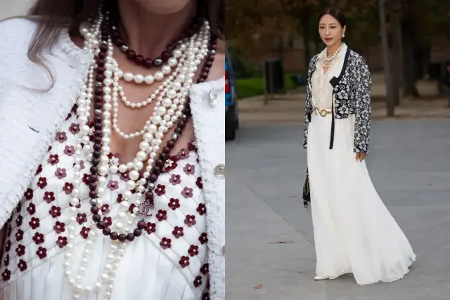 Elegancka kobieta w styl retro ubrania, z wieloma naszyjnikami z pereł i kamieni, w białej sukni i ozdobnej marynarce.